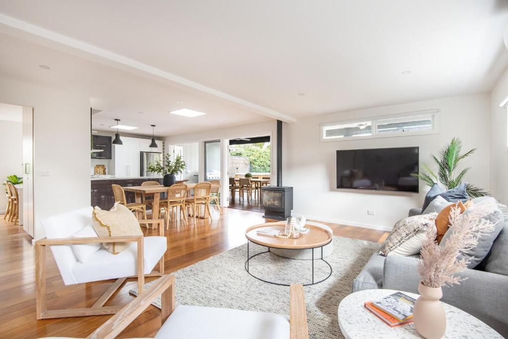 una sala de estar con un sofá y una mesa en Elizabeth Lodge with Spa Walk to beach, en Capel Sound