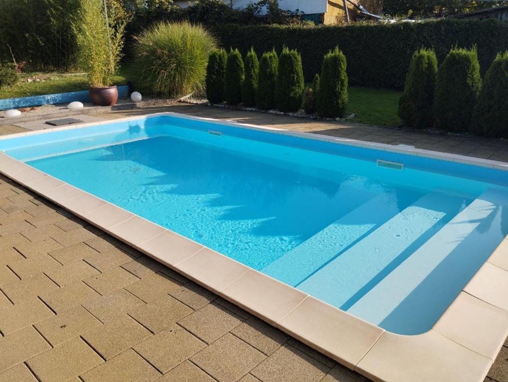 - une piscine bleue dans une cour avec une terrasse dans l'établissement Guesthouse Ursula, à Čakovec