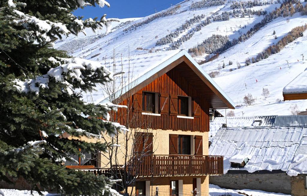 a log cabin with a balcony in the snow at Chalet Alpina in Les Deux Alpes