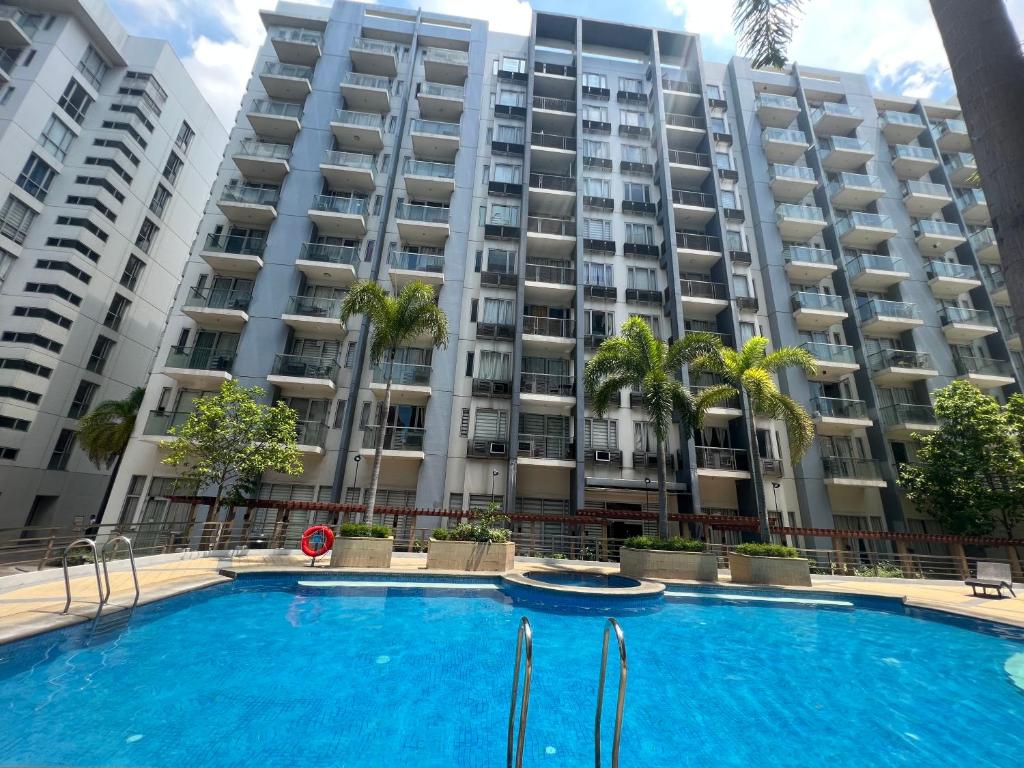 uma piscina em frente a um grande edifício de apartamentos em Vevilyn Condotel em Manila