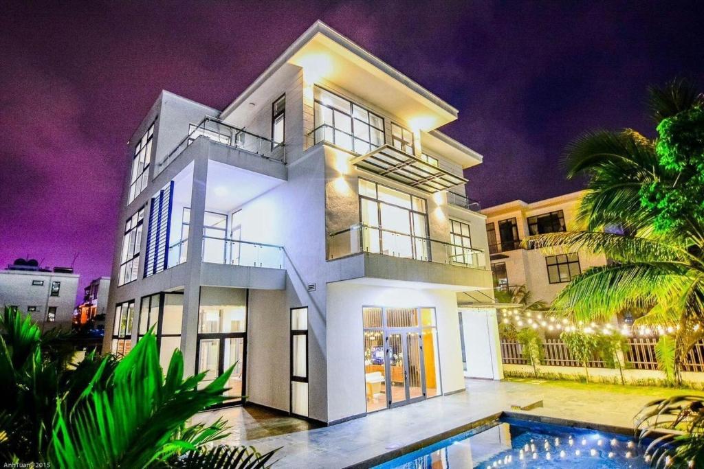 a large white house with a swimming pool in front of it at Sea Villa FLC Sầm Sơn - Villa SB-NT in Sầm Sơn