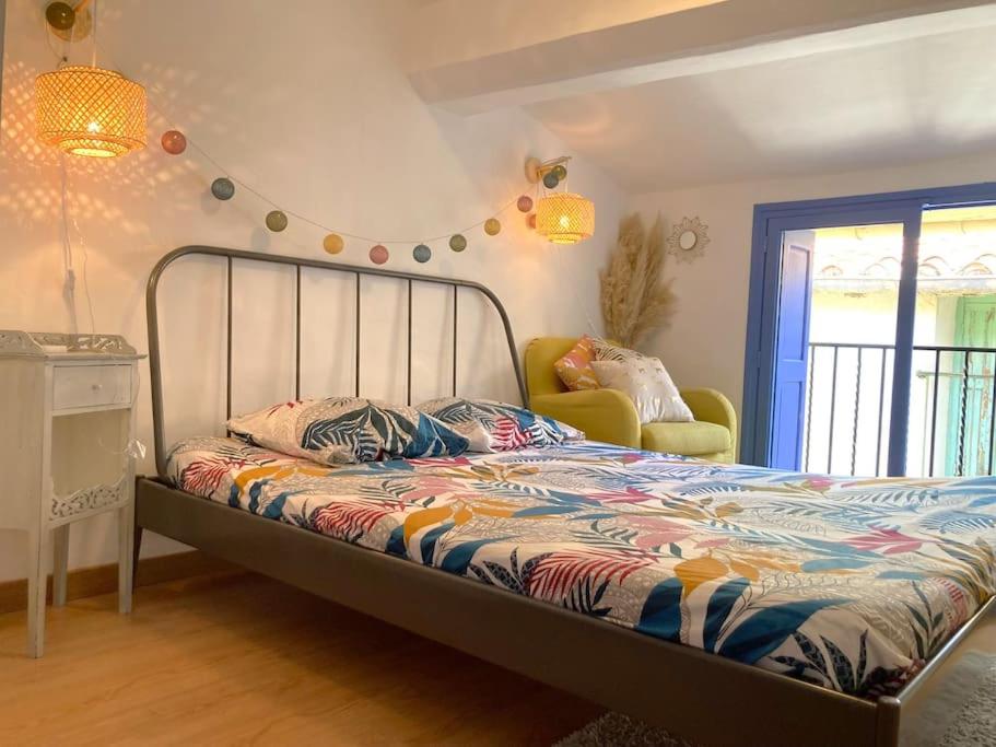 une chambre avec un lit et une chaise dans l'établissement Maisonnette à deux pas de la plage., à Collioure