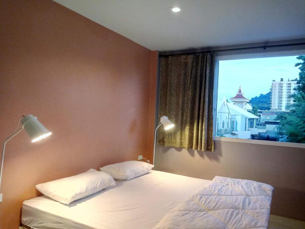 ein Schlafzimmer mit einem Bett und einem großen Fenster in der Unterkunft In Phuket House in Phuket