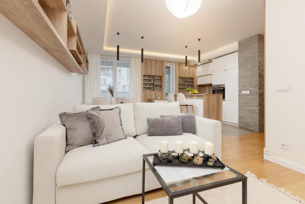 a living room with a white couch and a table at Spacious Lodygowa Apartment Ideal for Families by Renters in Warsaw