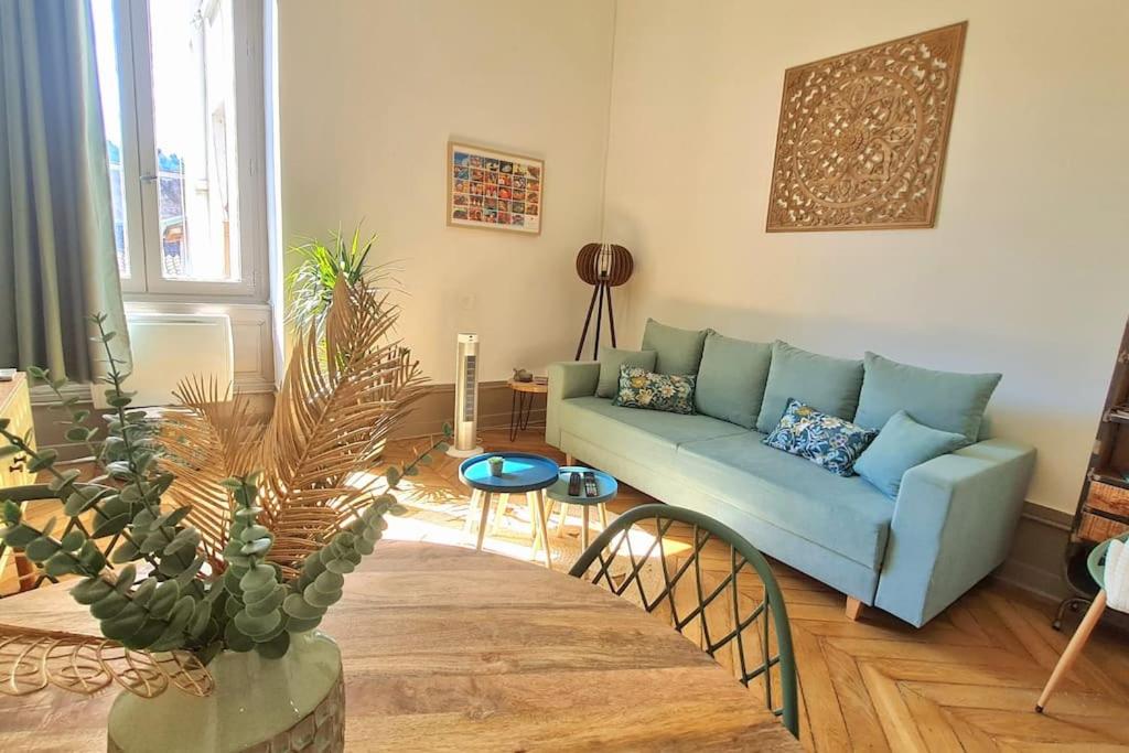 uma sala de estar com um sofá azul e uma mesa em L'Escapade Bohême em Vienne