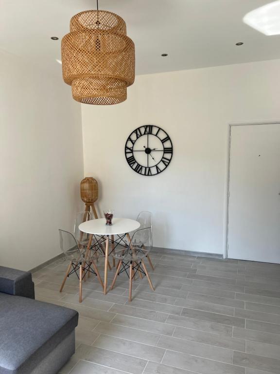 a dining room with a table and a clock on the wall at Grand T2 climatisé a 5 min de la gare st-charles - vieux port in Marseille