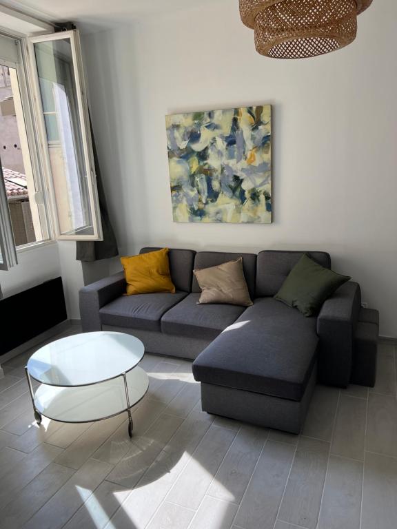 a living room with a couch and a coffee table at Grand T2 climatisé a 5 min de la gare st-charles - vieux port in Marseille
