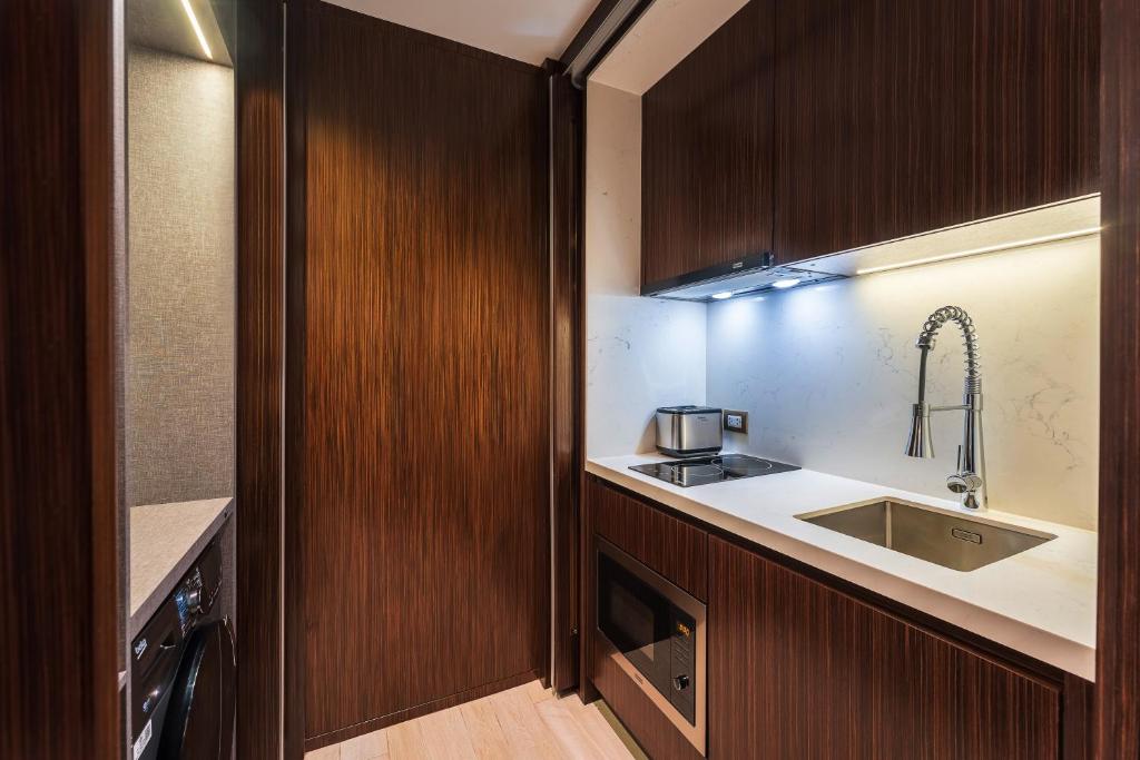 A compact built-in kitchenette with an induction hob, sink, kettle, and microwave.