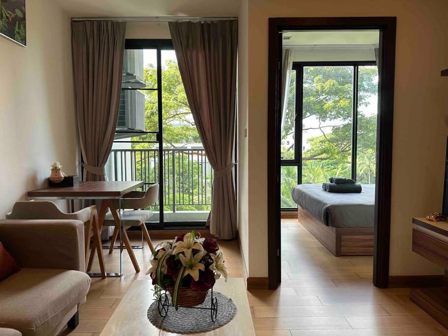 a living room with a room with a bed and a table at The Astra condo Deluxe Room in Chiang Mai