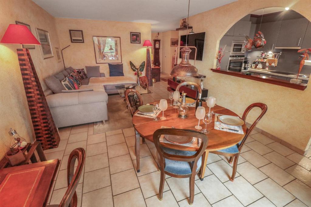 Super appartement au coeur de Martigny في مارتيني فيل: غرفة معيشة مع طاولة وكراسي وأريكة
