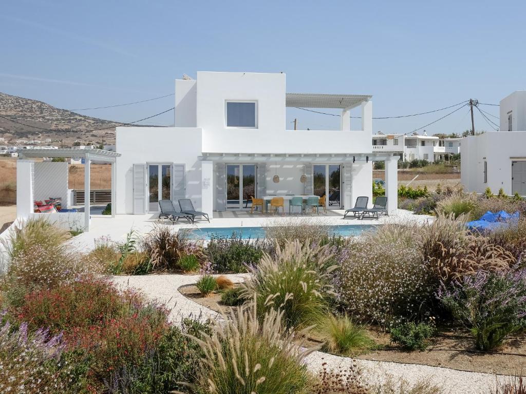 a white house with a swimming pool in the desert at Villa Aura in Kastraki Naxou