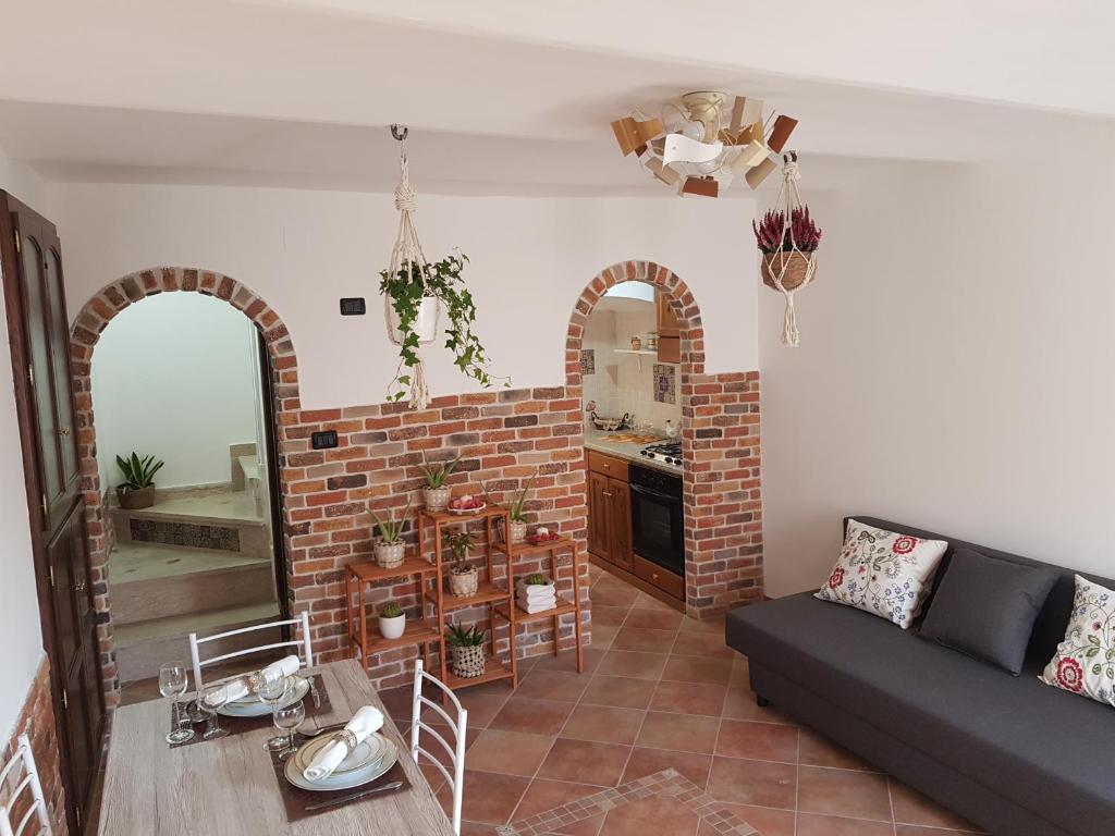 a living room with a couch and a brick wall at La Tana degli Orsetti in Barrea