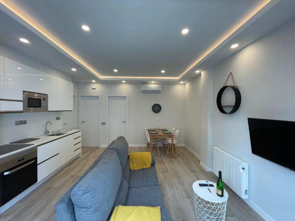 a living room with a blue couch and a kitchen at manresa universidad in Manresa