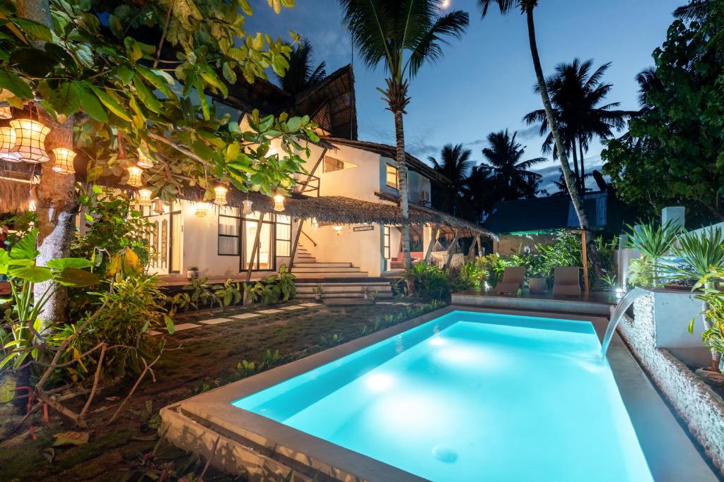a swimming pool in front of a house at Casa Bianca Siargao in General Luna