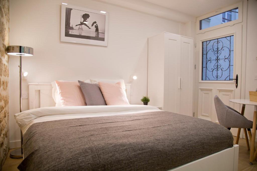 une chambre avec un grand lit avec une fenêtre dans l'établissement Dauphine Chic & Charme, à Paris