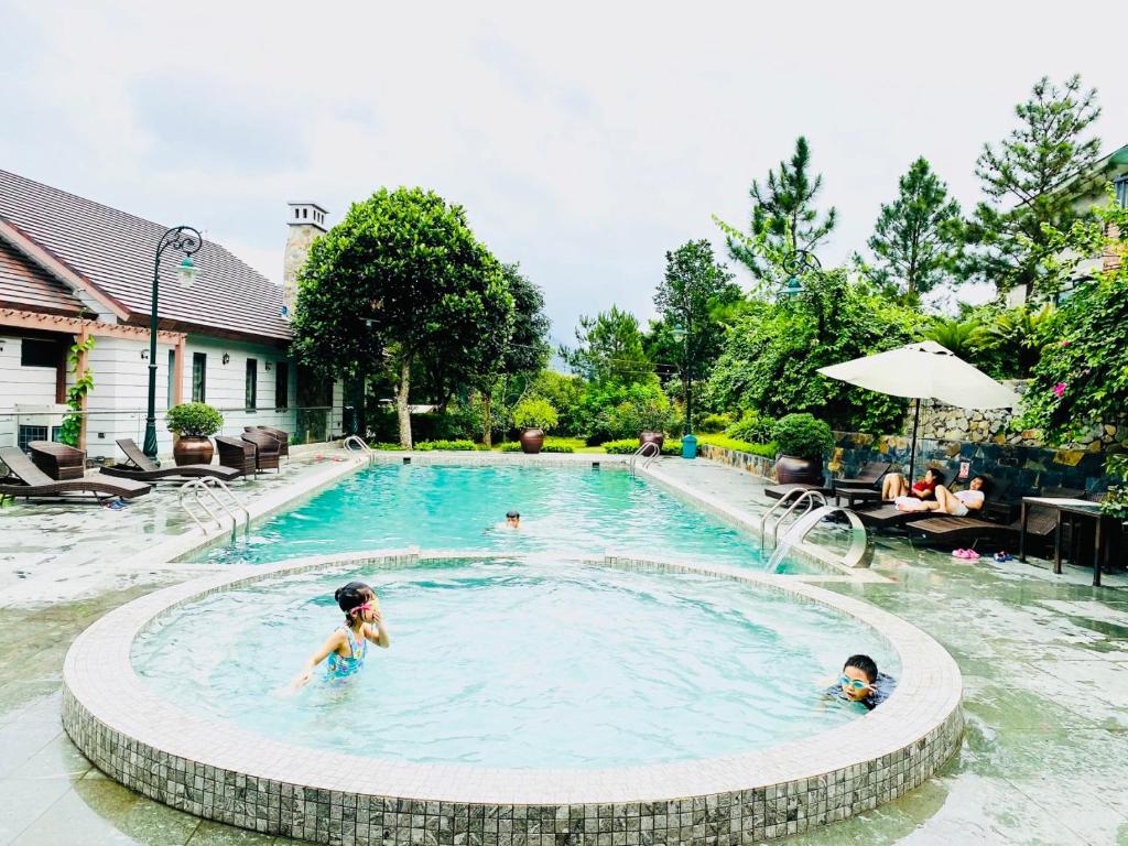 un grupo de niños jugando en una piscina en An Villa Venuestay, en Tam Ðảo