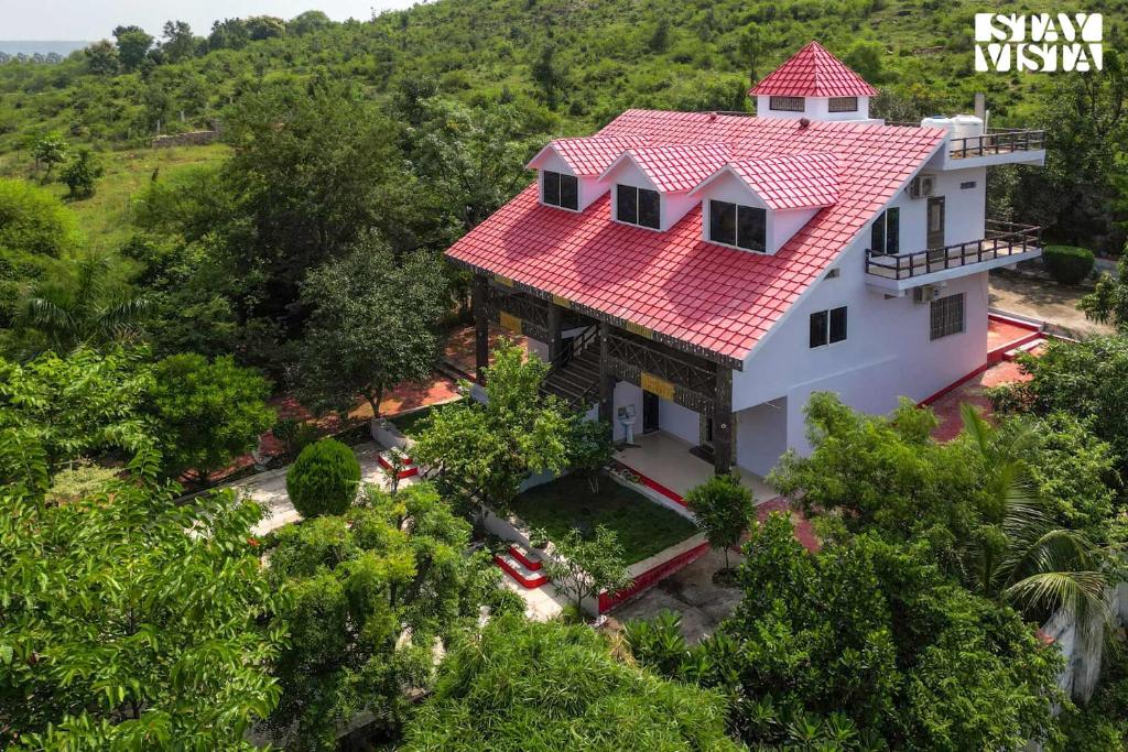 einen Blick über ein Haus mit rotem Dach in der Unterkunft StayVista's Sunara Trails - Pet-Friendly, Mountainside Retreat with Balcony & Indoor-Outdoor Games - Near Panna National Park in Panna