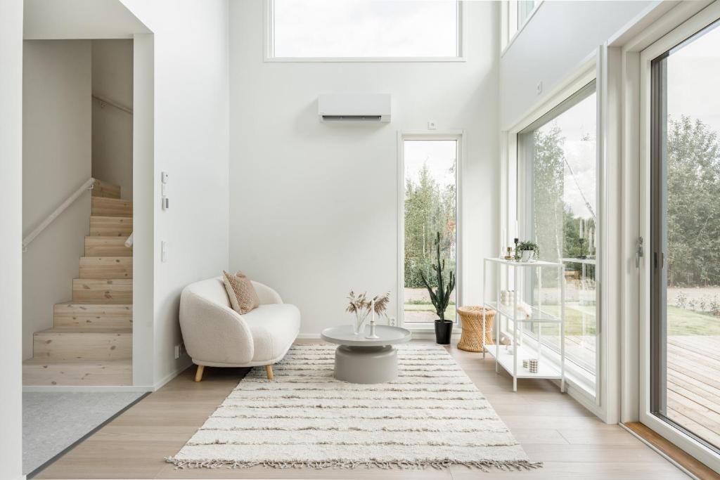 a living room with a chair and a table at Lovely Scandinavian Duplex for 6 and babybed in Vantaa Hiekkaharju Tikkurila in Vantaa