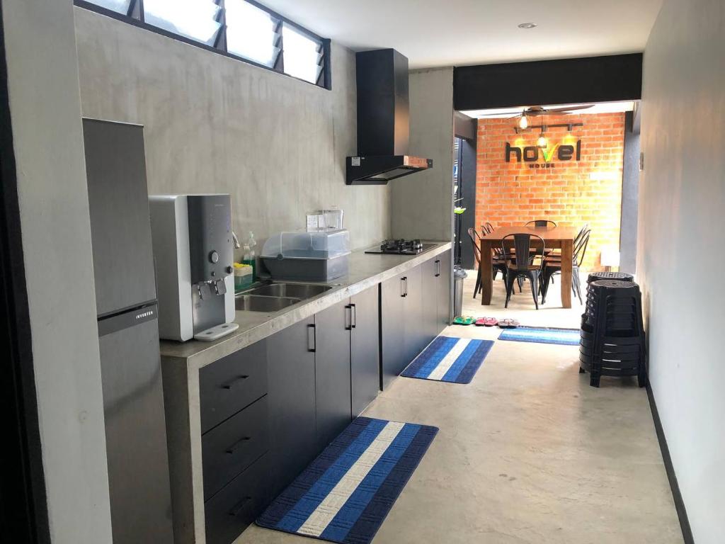 eine Küche mit weißen Schränken und ein Esszimmer in der Unterkunft Hovel House in Alor Setar