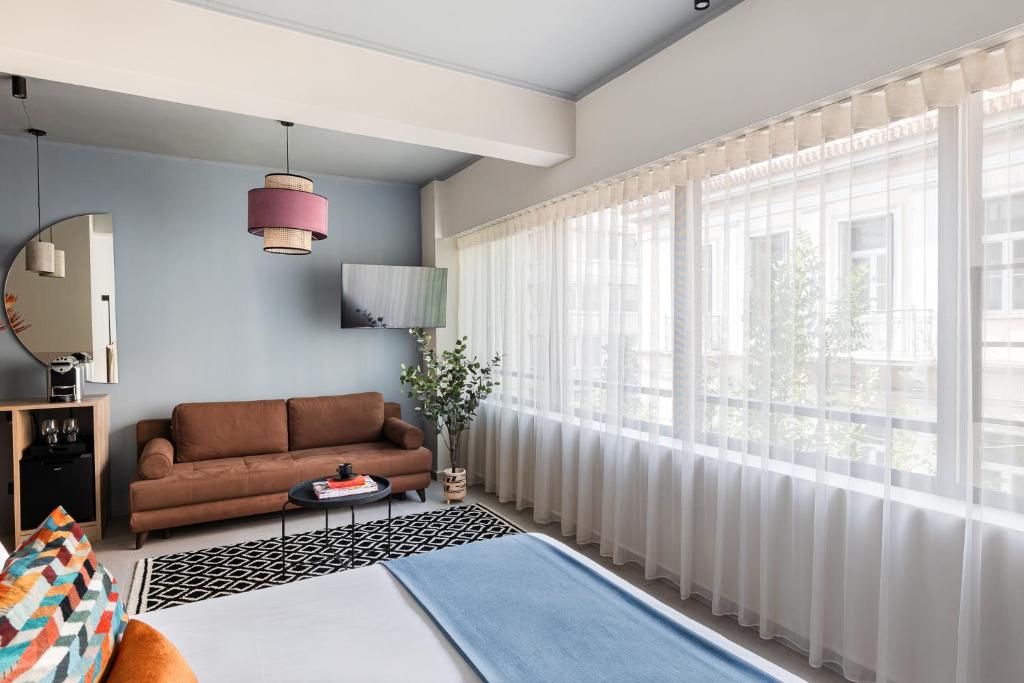 a living room with a couch and a window at Airio Athens Suites in Athens