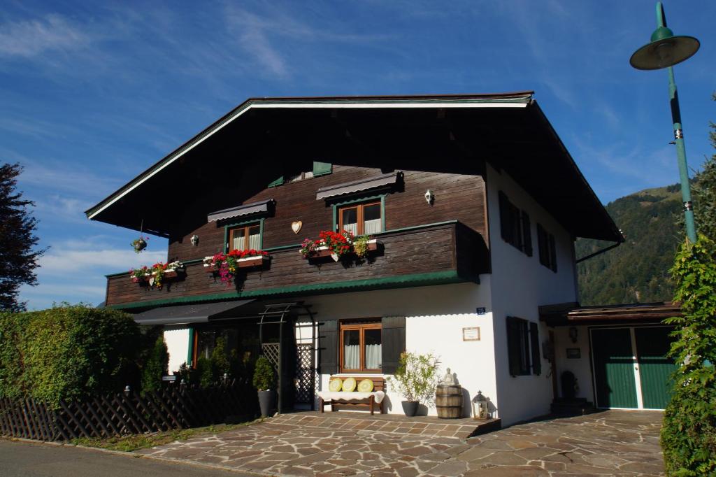 une maison avec des boîtes de fleurs sur le toit dans l'établissement Mental-Oase Haunold, à Erpfendorf