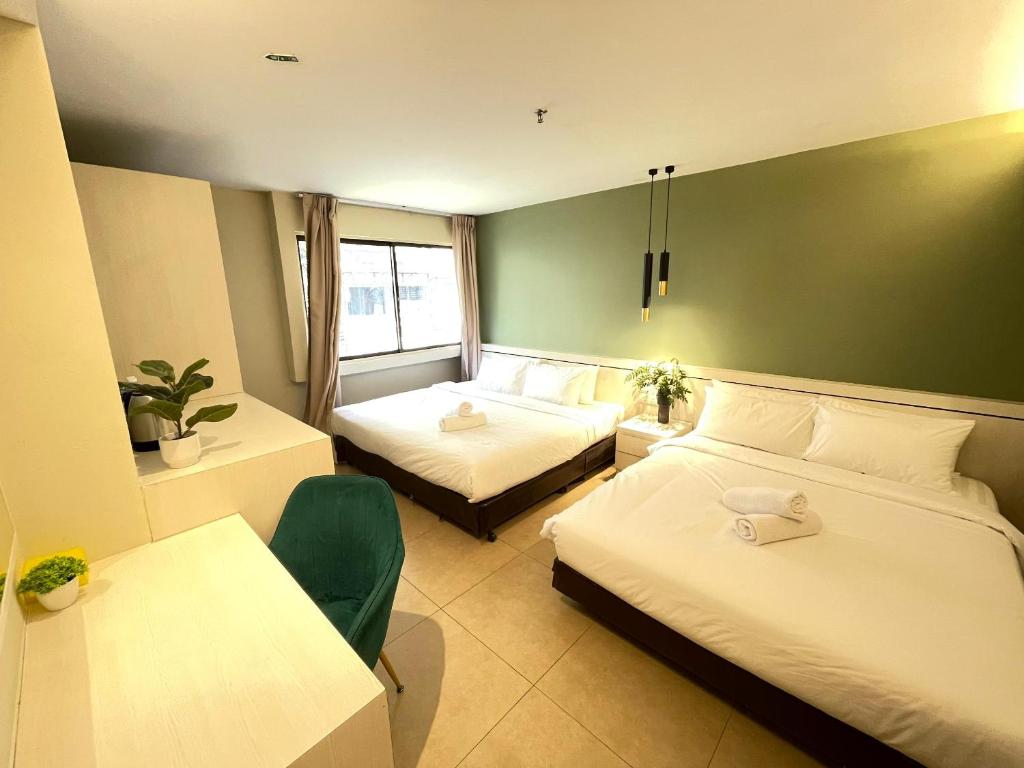 Habitación de hotel con 2 camas y mesa en Swing & Pillows - Sungei Wang Hotel Bukit Bintang en Kuala Lumpur