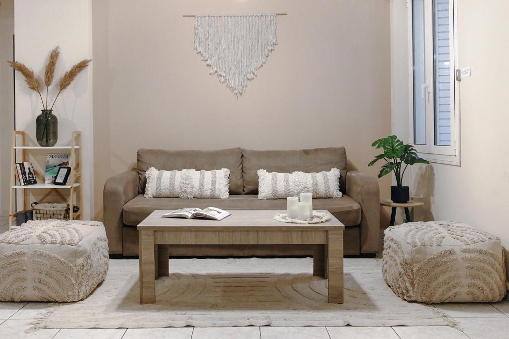 uma sala de estar com um sofá e uma mesa de centro em Acropolis Boho Bliss em Atenas