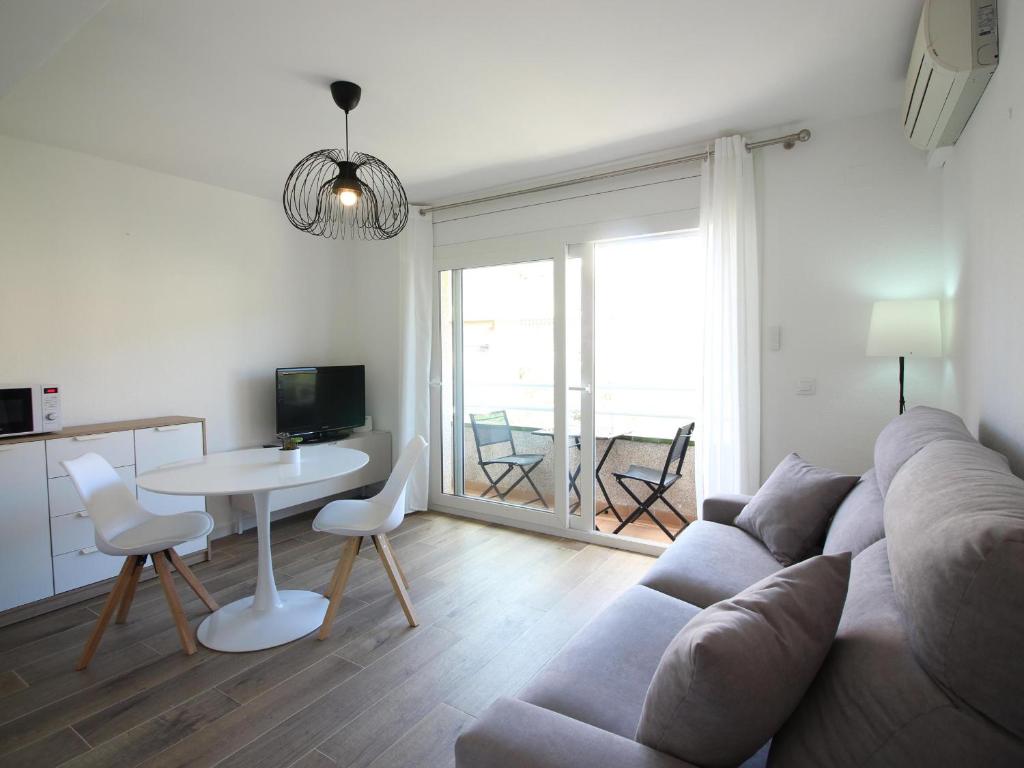 Apartamento Roses, 1 dormitorio, 4 personas - ES-228-110 في روساس: غرفة معيشة مع أريكة وطاولة وكراسي