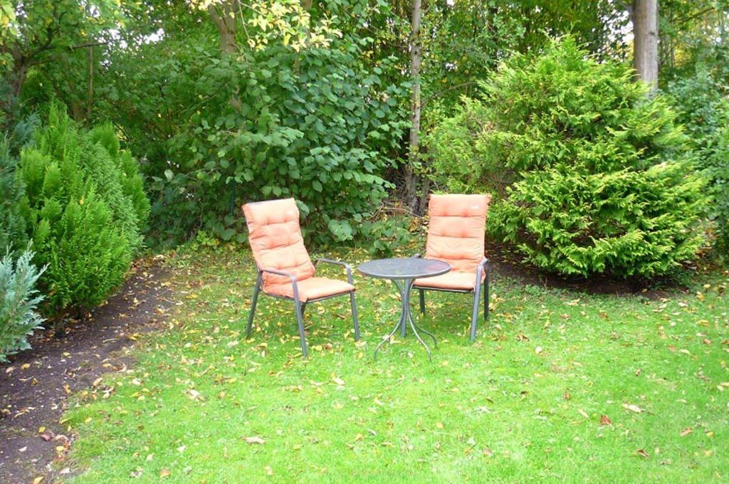 twee stoelen en een tafel in het gras bij Bett u Butze Timmendorfer Strand Ferienwohnung in Timmendorfer Strand
