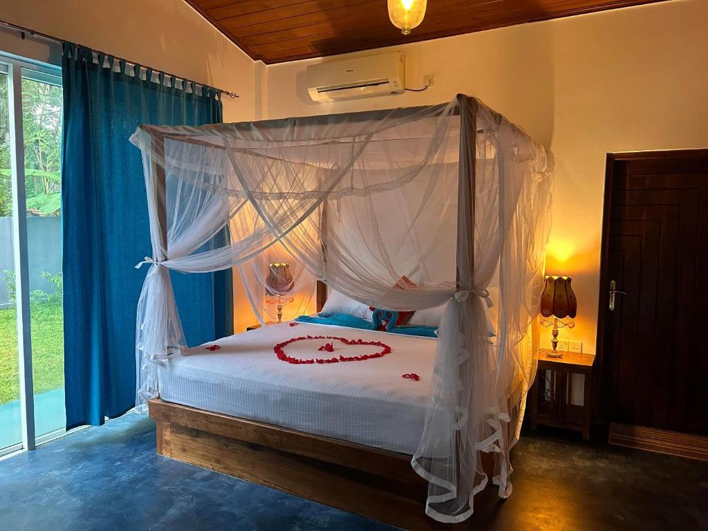 a bedroom with a bed with a canopy at Amba Kola Udawalawa in Udawalawe