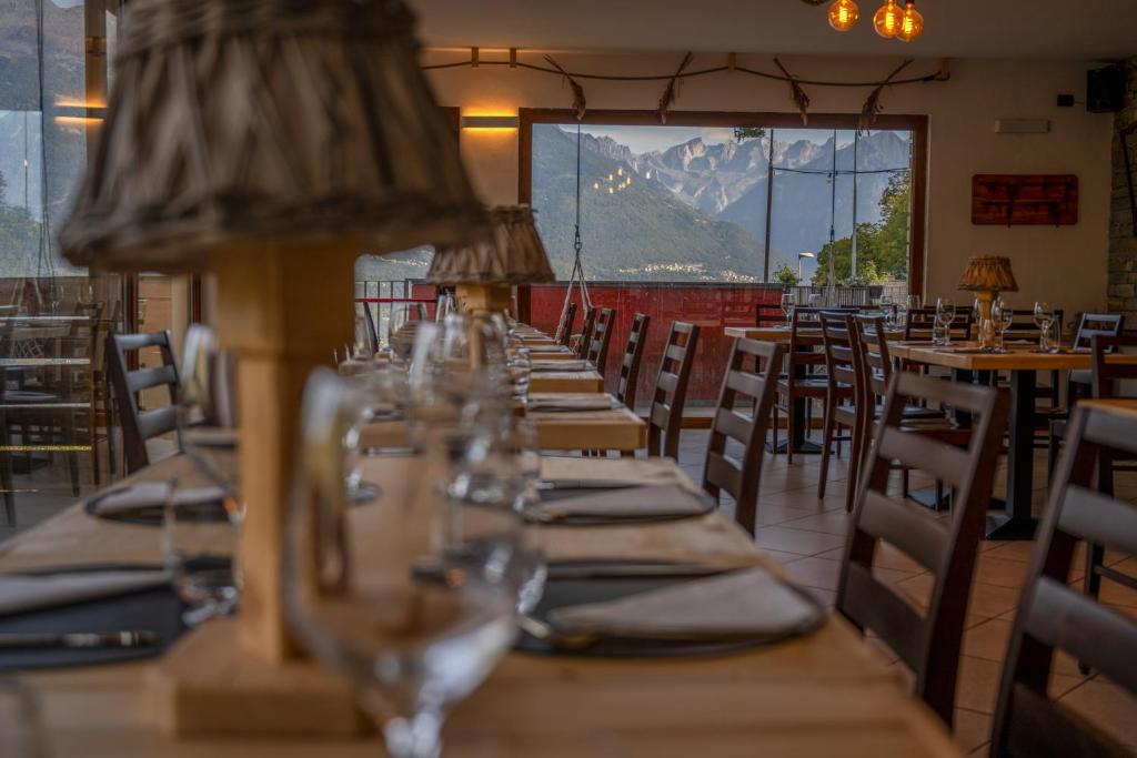 eine Reihe von Tischen und Stühlen in einem Restaurant in der Unterkunft Una Finestra Sulle Alpi in Bema