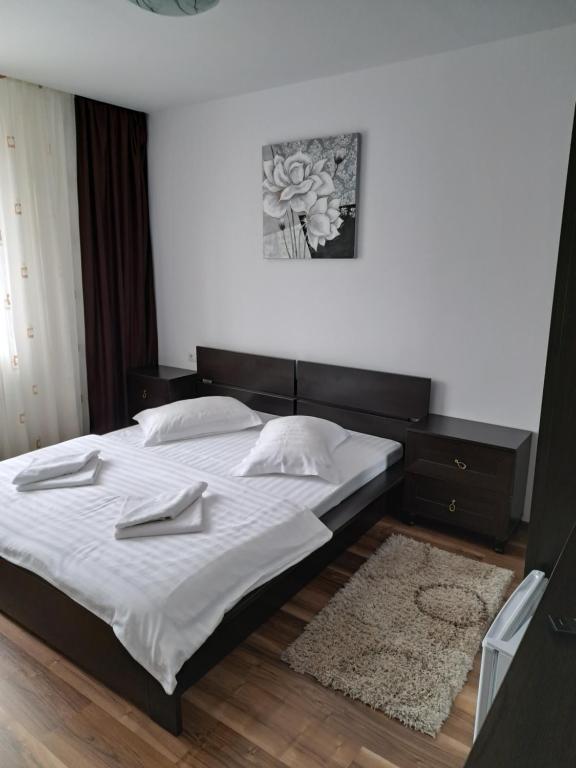 a bedroom with a large bed with white sheets at Drag De Munte in Predeal