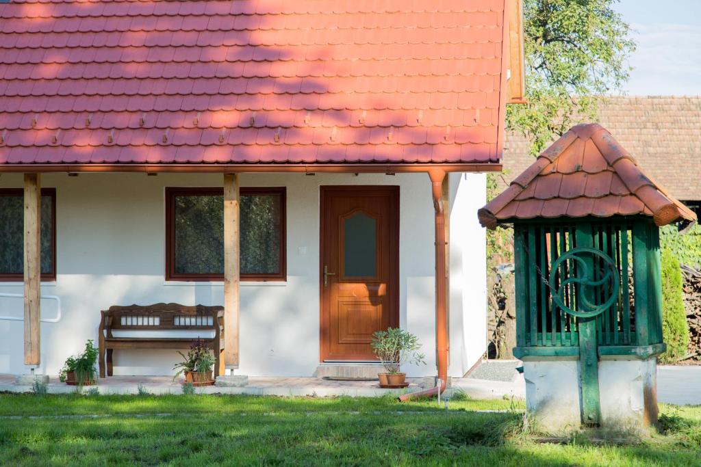 une maison avec un toit orange et une porte en bois dans l'établissement Almafás Apartmanház Őrség, à Kerkakutas