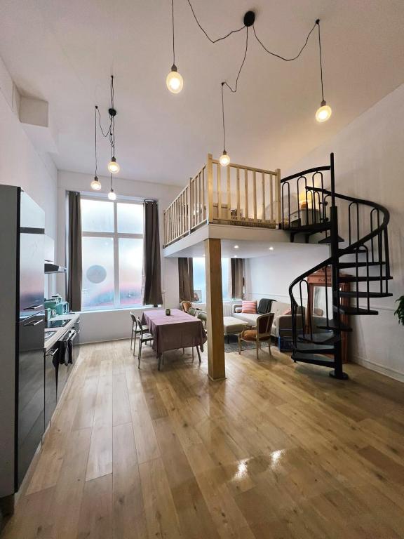 un salon avec un escalier en colimaçon dans un loft dans l'établissement Appartement studio loft cosy centre st Etienne, à Saint-Étienne