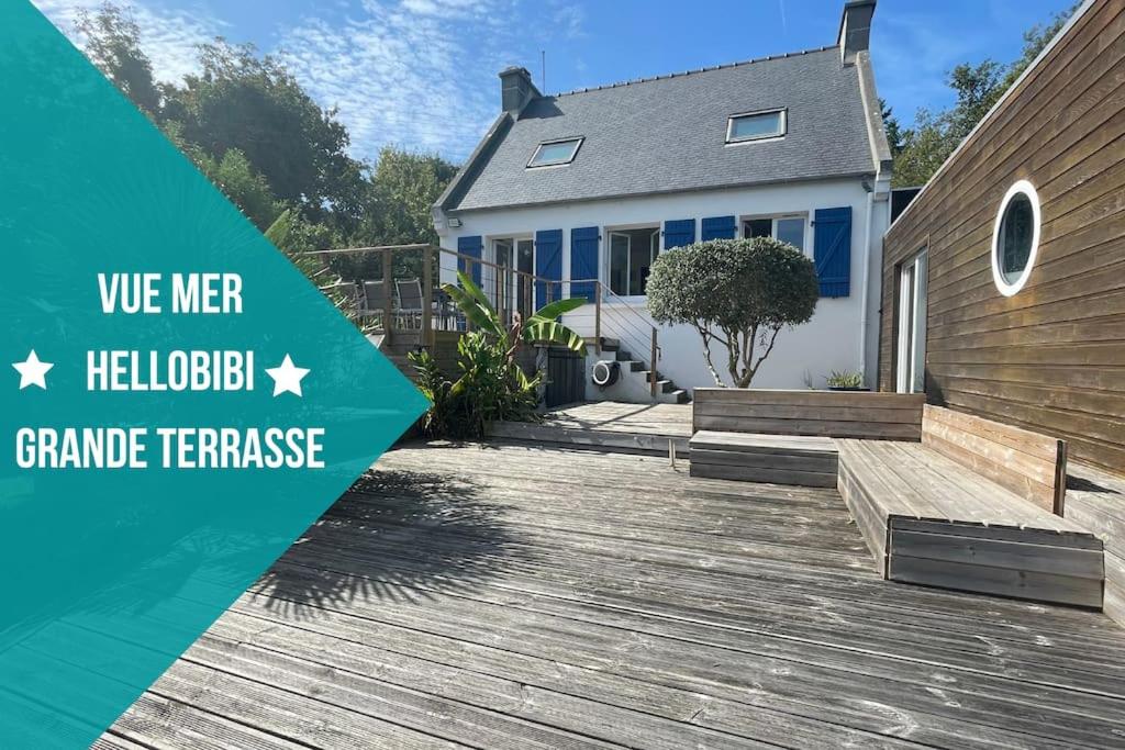 a house with a wooden deck with the words we need a backyard grand traverse at Ti-vakañsoù - maison de vacances in Roscanvel