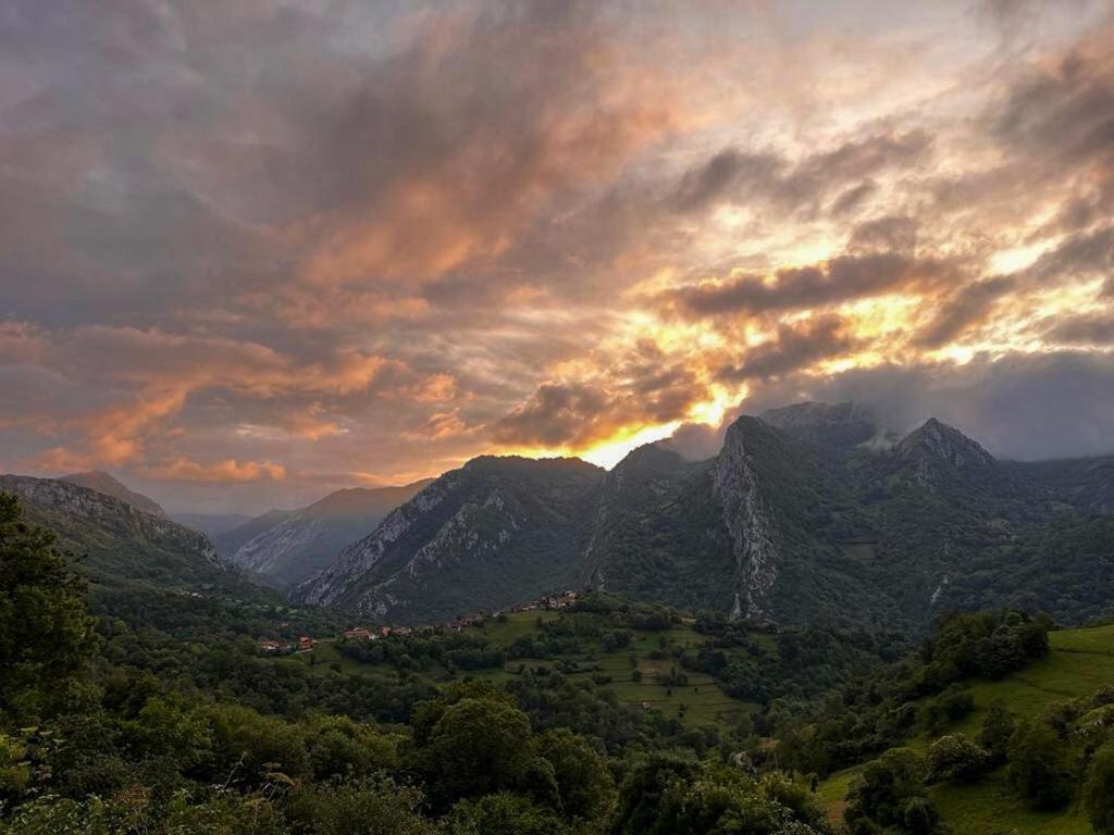 a view of a mountain range with the sun setting at El Refugio del Busgosu in Pen