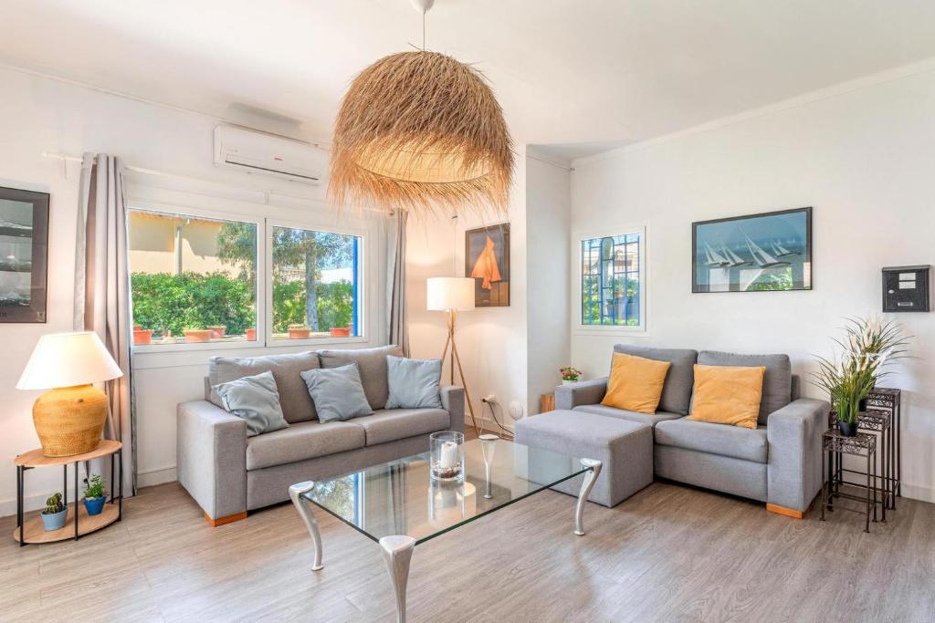 a living room with two couches and a glass table at Casa a metros del Mar in Playa de Muro