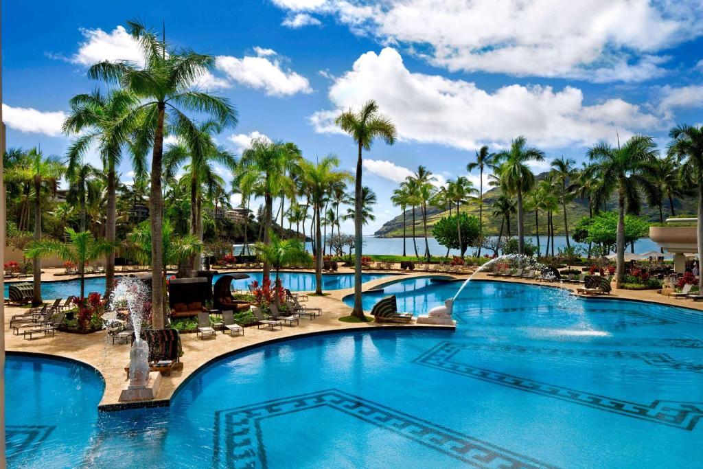 a pool at the resort with palm trees at The Royal Sonesta Kauai Resort Lihue in Lihue
