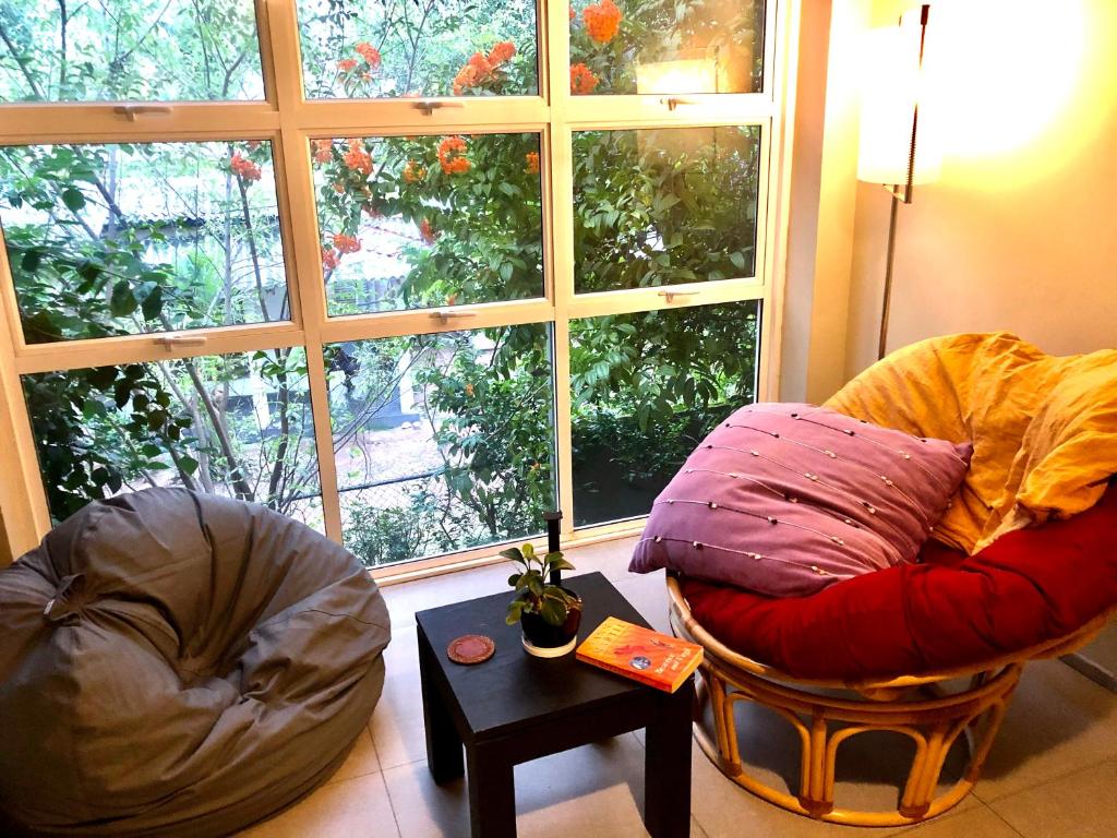 ein Wohnzimmer mit 2 Stühlen und einem großen Fenster in der Unterkunft Write Asia Hollidays in Gampaha