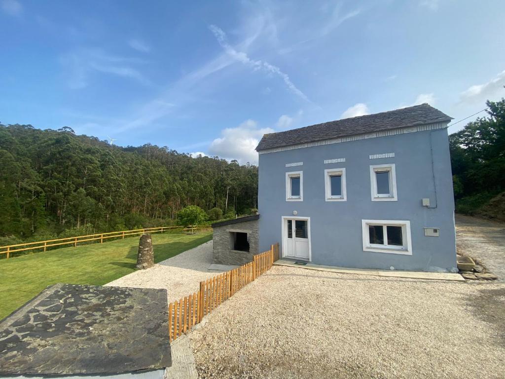 a blue house sitting on top of a gravel yard at Casa Mariñao 1 in Loiba