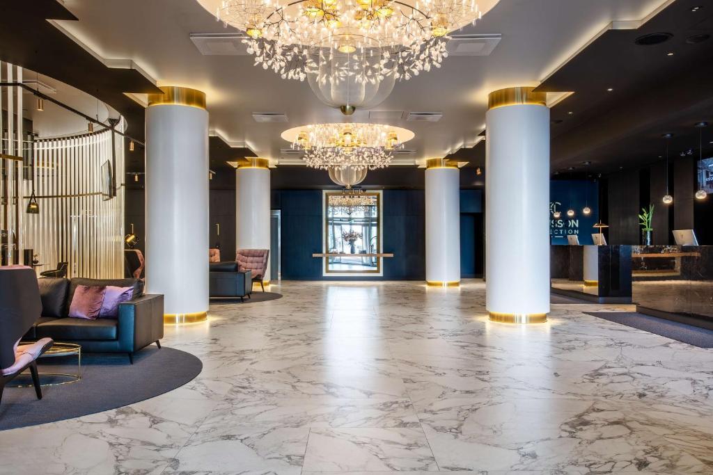 a lobby of a hotel with columns and chandeliers at Radisson Collection Hotel, Tallinn in Tallinn