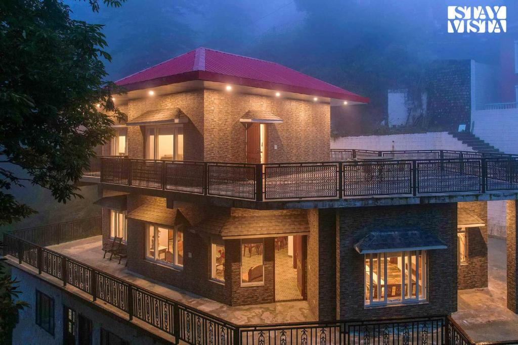 a house with a balcony on top of it at StayVista at Pineview @ Albert Estate in Mussoorie