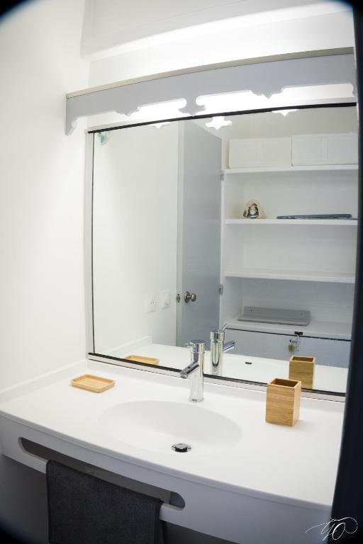 un bagno con specchio sopra un lavandino di GAP a Le Diamant