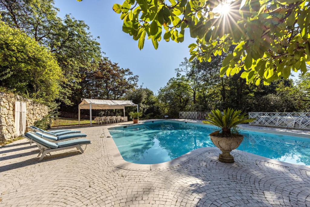 uma piscina com um banco ao lado de uma árvore em Villa Magnolia em Arcugnano