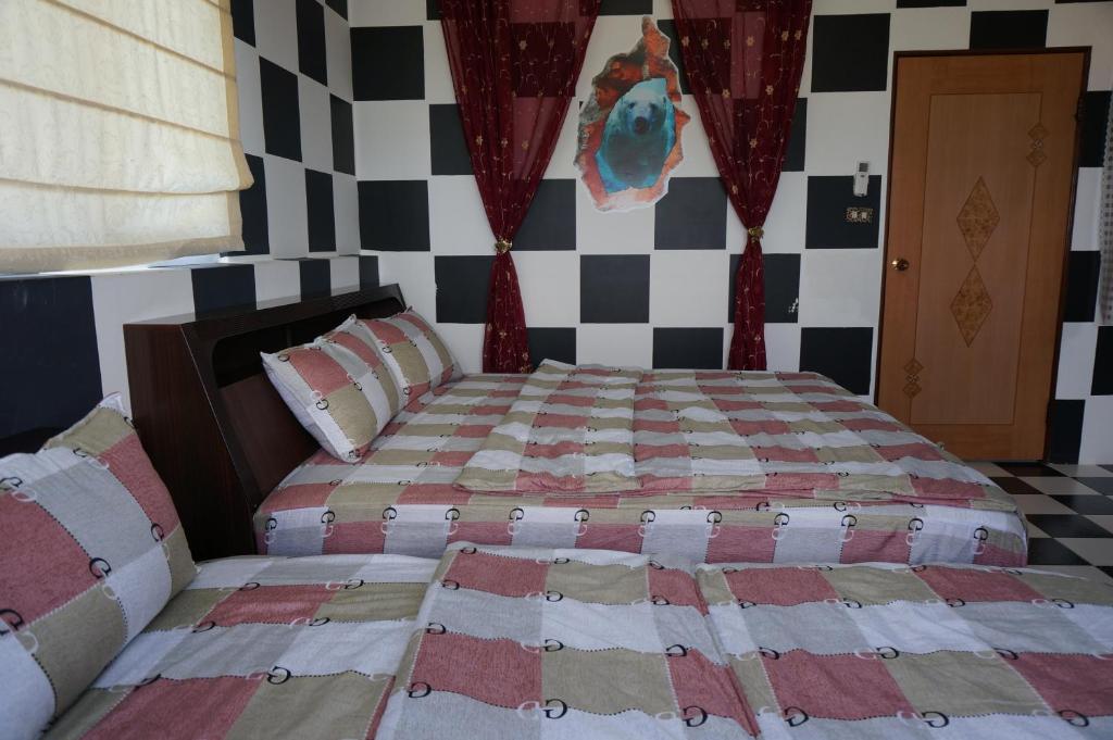 a bedroom with a bed with a checkered wall at See Starsea Guest House in Magong