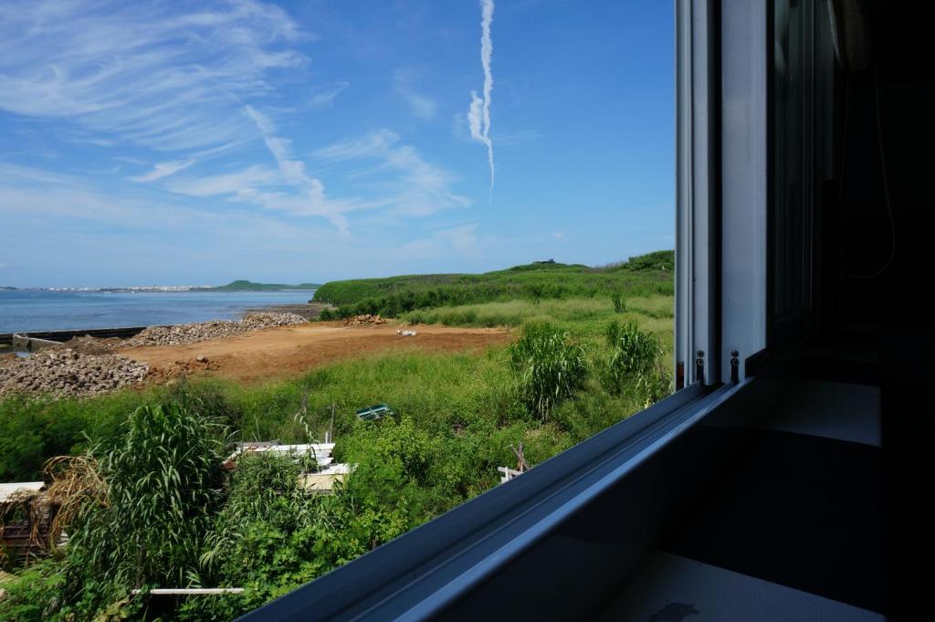 馬公市的住宿－觀星海民宿，从房子的窗户可欣赏到海滩景色