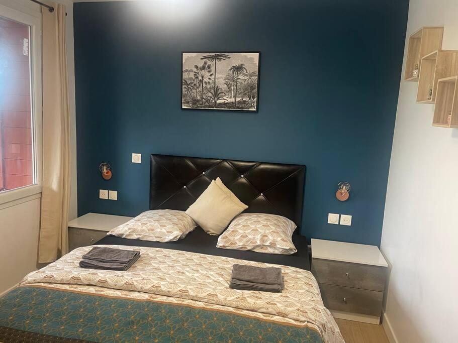 a bedroom with a bed and a blue wall at L5&#47;villiers-le-bel proche Roissy in Villiers-le-Bel