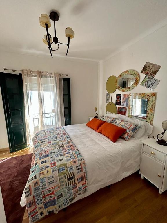 - une chambre avec un grand lit et une grande fenêtre dans l'établissement Mouradia Moura, à Moura
