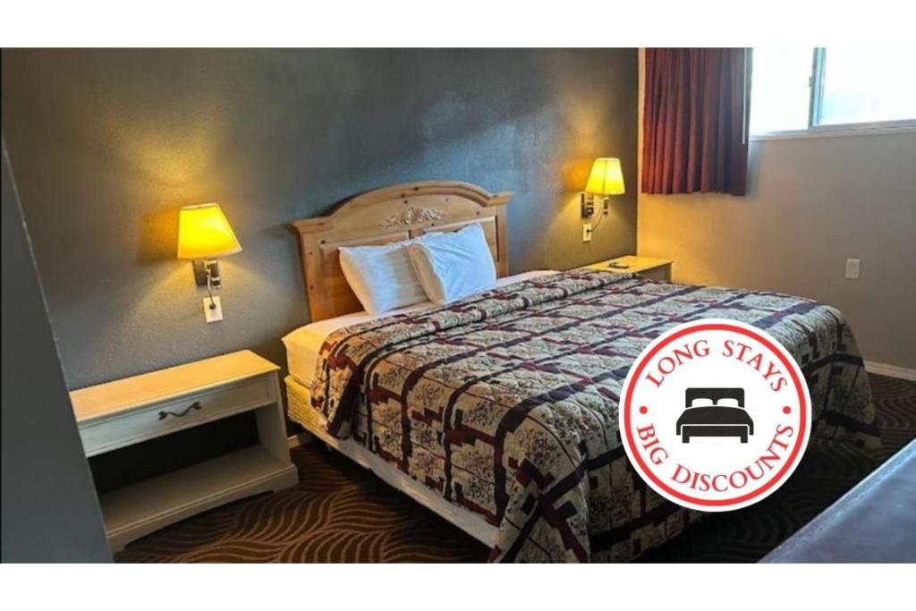 a hotel room with a bed with a sign on it at Love Hotels Western Holiday by OYO at Harlan Lake NE in Alma