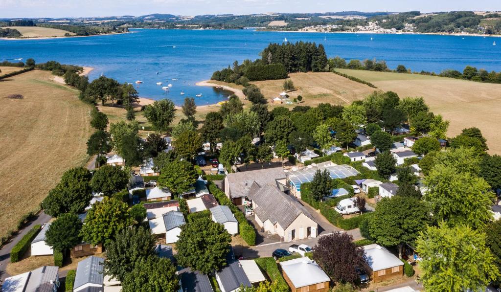 an aerial view of a house with the lake in the background at Parc du Charouzech in Salles-Curan
